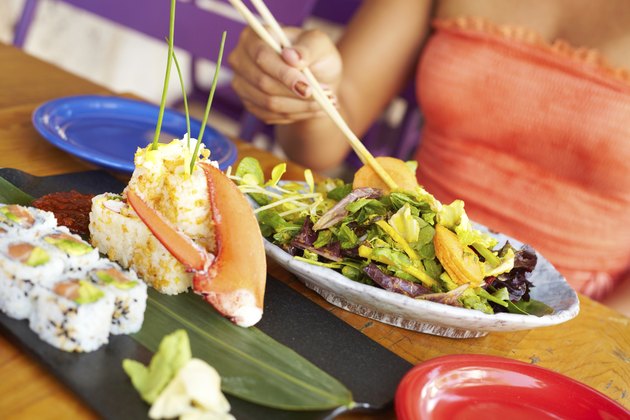 Colse Up Of Mixed Race Woman Enjoying Meal At Restaurant