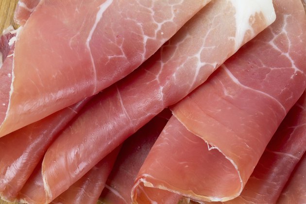 sliced prosciutto on a wooden board