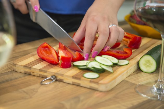 Woman slicing bell pepper for a healthy salad.