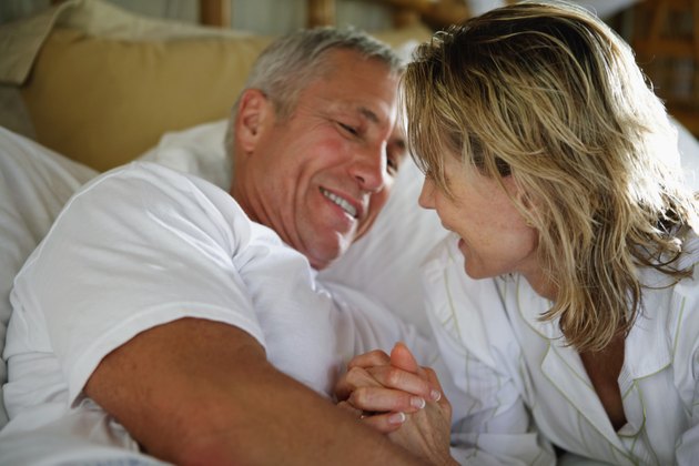 Senior couple smiling in bed, close-up