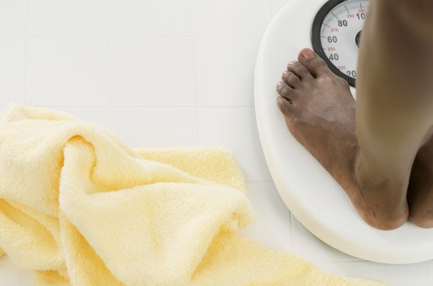 View of feet of a woman standing on weighing scale