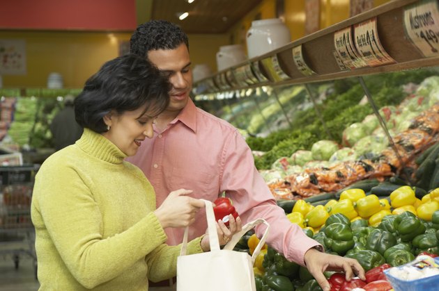 Mid adult woman holding red bell peppers