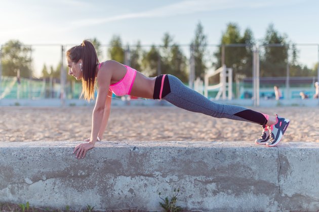 Fitness woman doing push ups Outdoor training workout summer evening