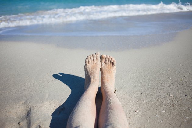 legs on the beach, female feet in sand