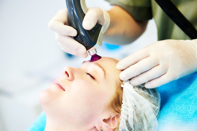 woman under laser cosmetology procedure