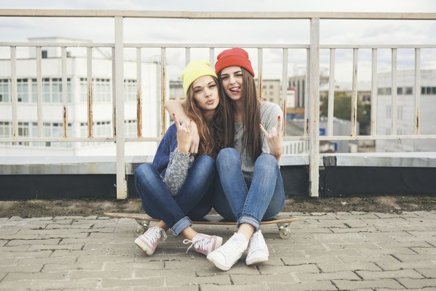 Two young longboarding girl friends