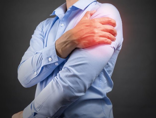 man holding his shoulder in pain