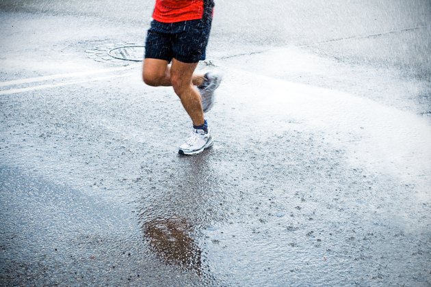 Marathon runner in rain on city street