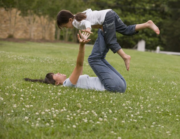 Asian mother playing with daughter in park
