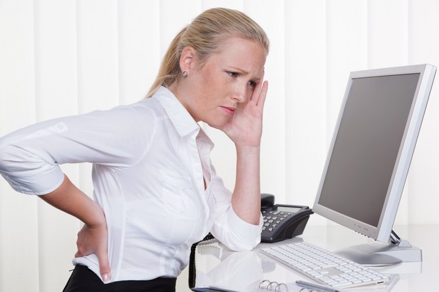 woman with back pain in the office