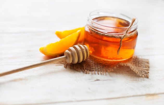 jar of honey and orange on wooden Table