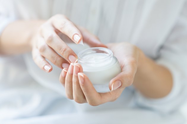 Beautiful woman hands applying moisturizer