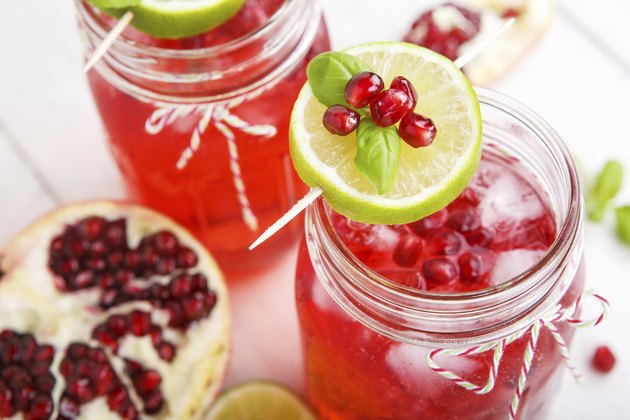 Two glasses with red pomgranate juice, lime and mint.