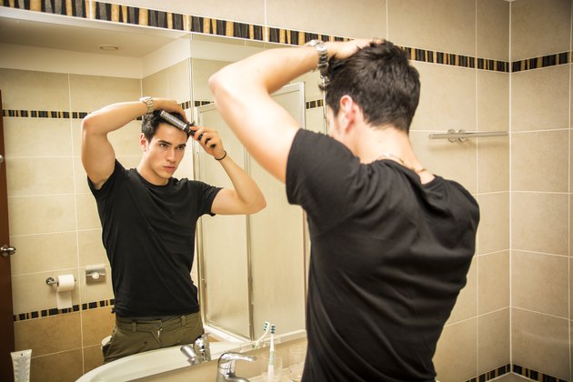 Reflection of Man Bushing Hair in Mirror