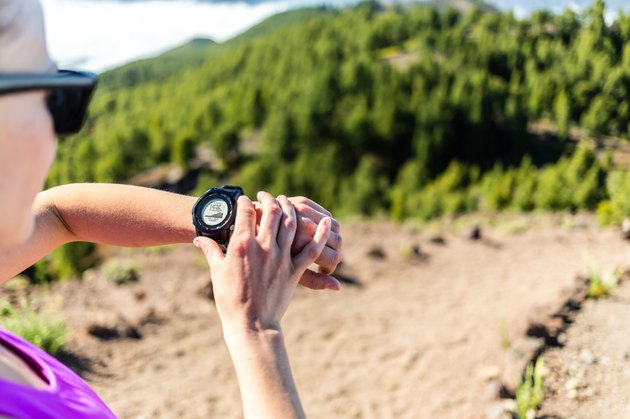 Trail runner looking at sport watch