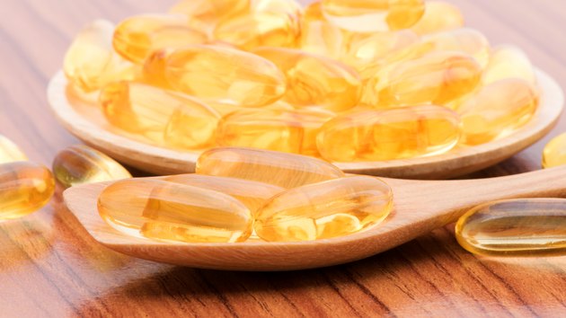 Close-up Fish oil capsules on wooden spoon