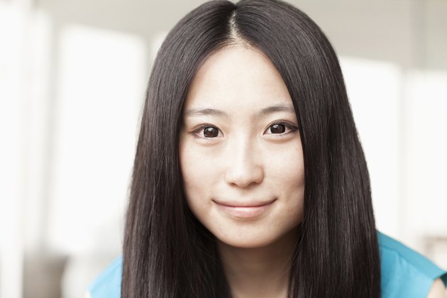 Portrait of smiling businesswoman with straight hair, head and shoulders