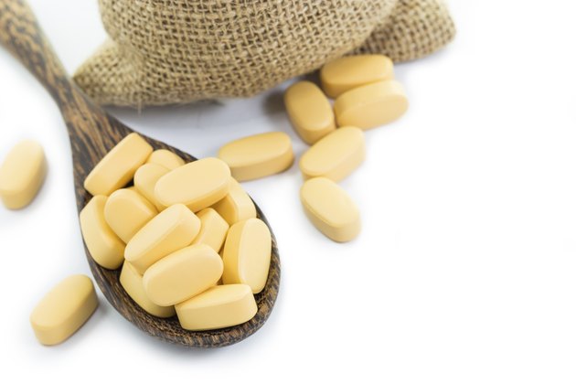Yellow pills in Empty burlap sack and on spoon