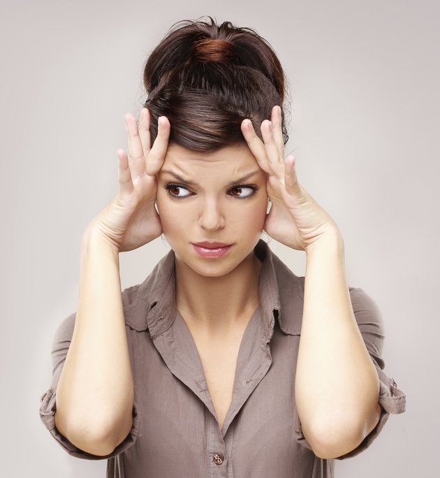 Portrait of young woman suffering from headache.
