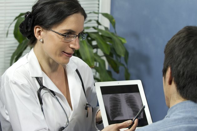 Female doctor showing patient's x-ray with tablet