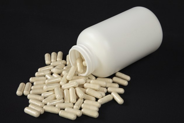 white bottle spilling beige caspules