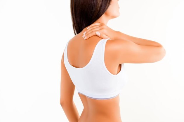 Brunette woman massaging her neck because it hurts