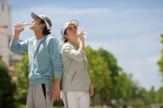 Couple drinking from water bottles