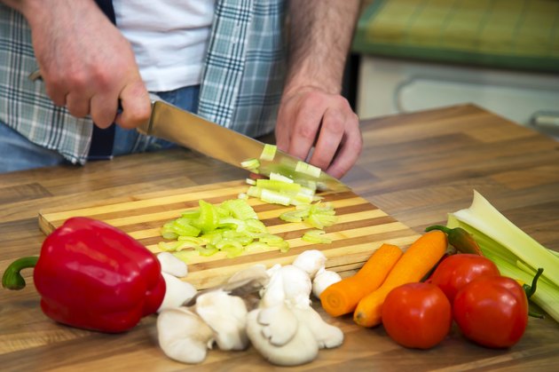 Close-up of man chopping fresh celery.