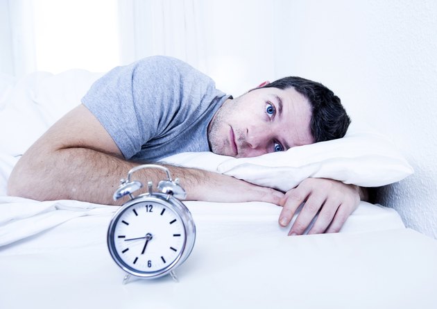 man in bed suffering insomnia and sleeping disorder