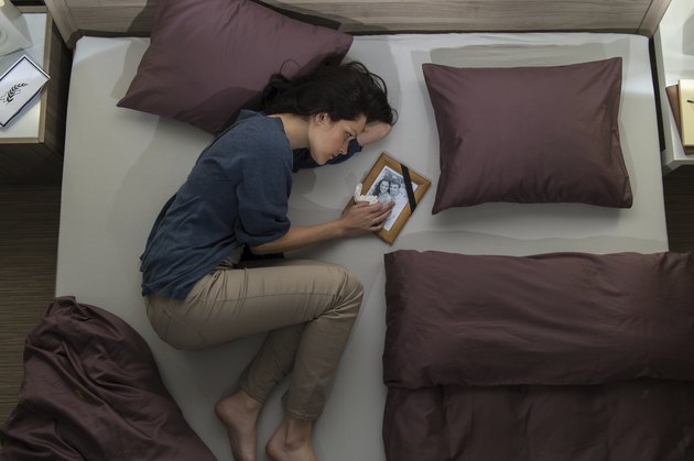 Young mourning woman lying in bed