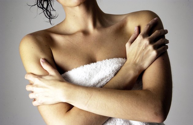 Woman in towel w/ her arms crossed across chest