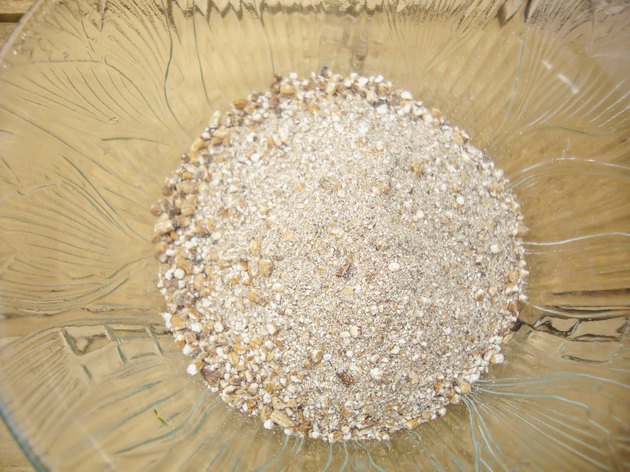 Rice bran in small cup on wooden background