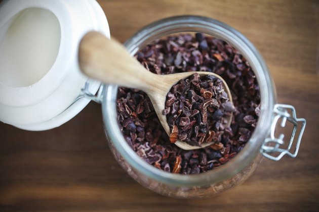 Cacao nibs or raw cocoa beans crushed in a jar