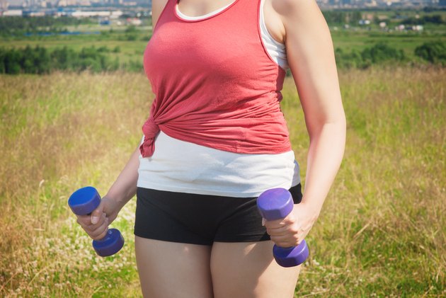 Plus size woman exercising with dumbbells