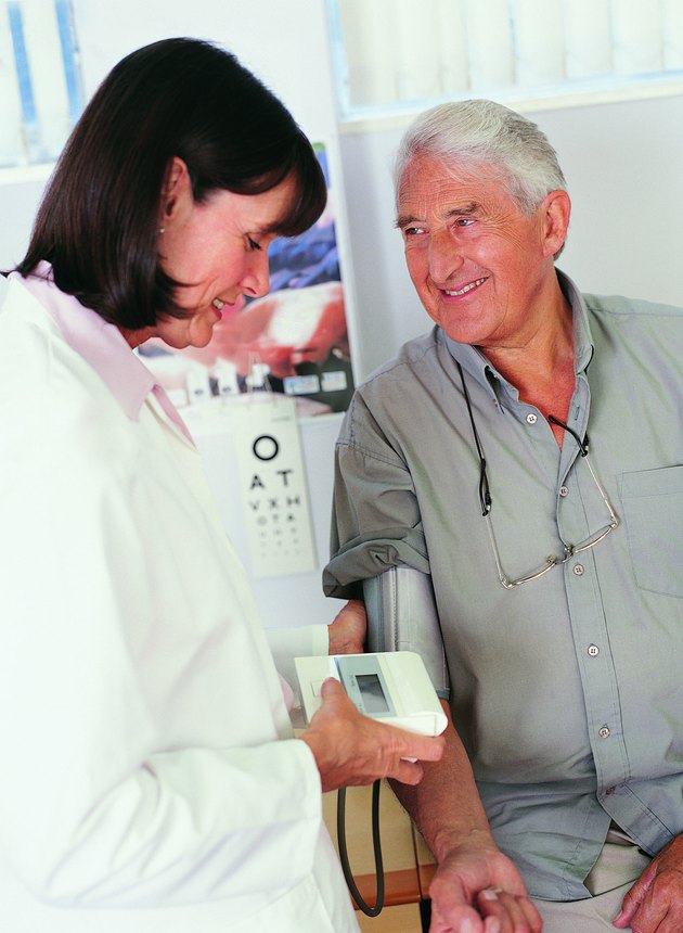 Female Doctor Taking Male Patient's Blood Pressure
