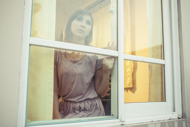 Young asian woman is sad at the window