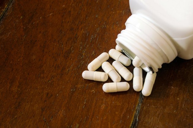 white capsule spilling out of a bottle