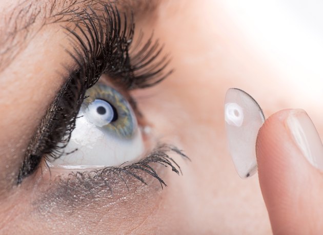 Young woman Inserting a contact lens