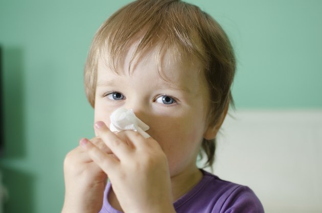 Little boy cleaning nose