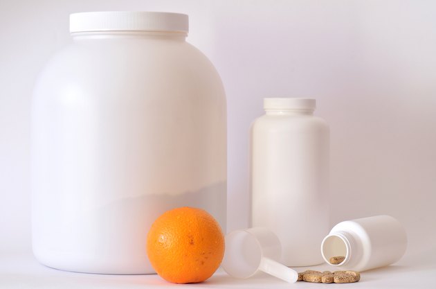 Big jar of protein powder, bottle of pills, orange