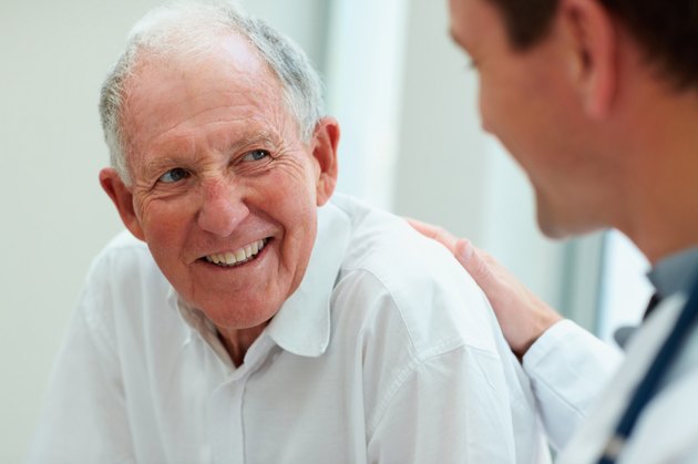 Happy old man having a casual talk with a doctor