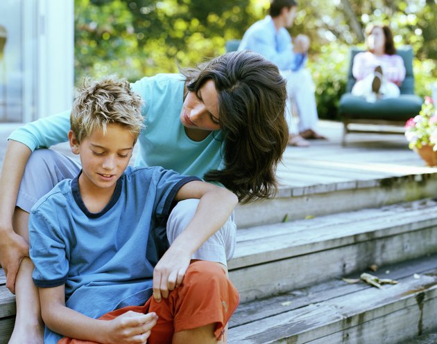 Mother sitting with son (9-11) on decking