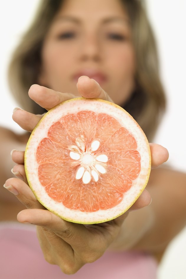 A young woman holding a sliced orange