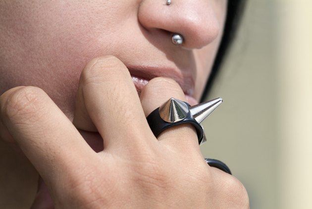 Young woman with nose studs and wearing studded ring, extreme close-up