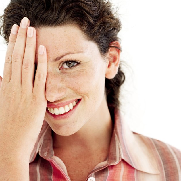 portrait of a young woman covering her face with her hand