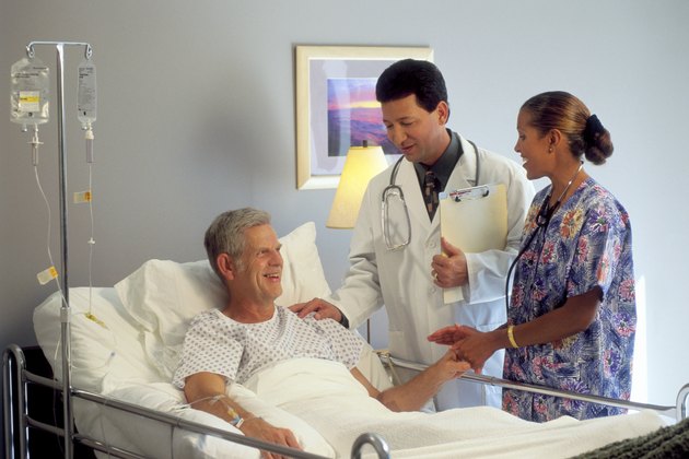 Doctor and nurse with patient in hospital bed