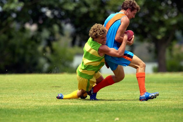 player tackles his opposition in football game