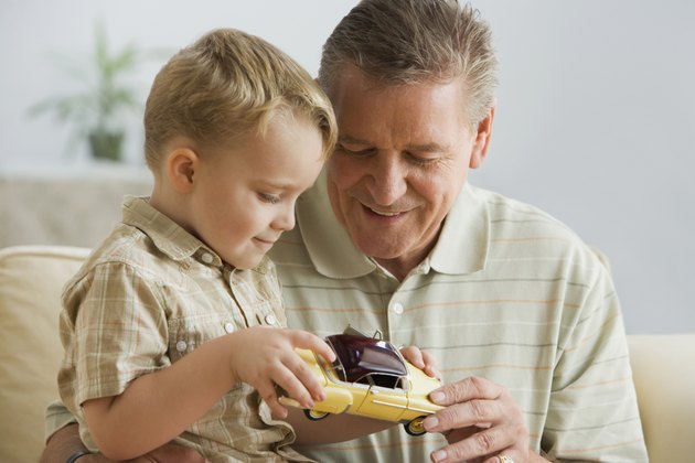 Grandfather and grandson looking at toy car