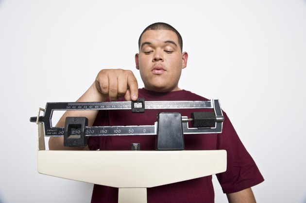 Teenage (16-17) boy using weight scales