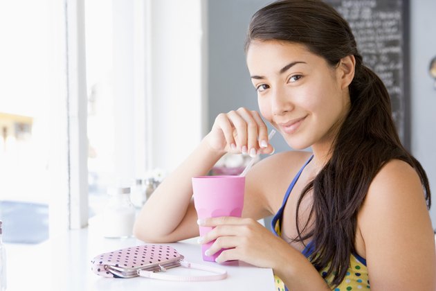 Woman drinking milkshake in cafe